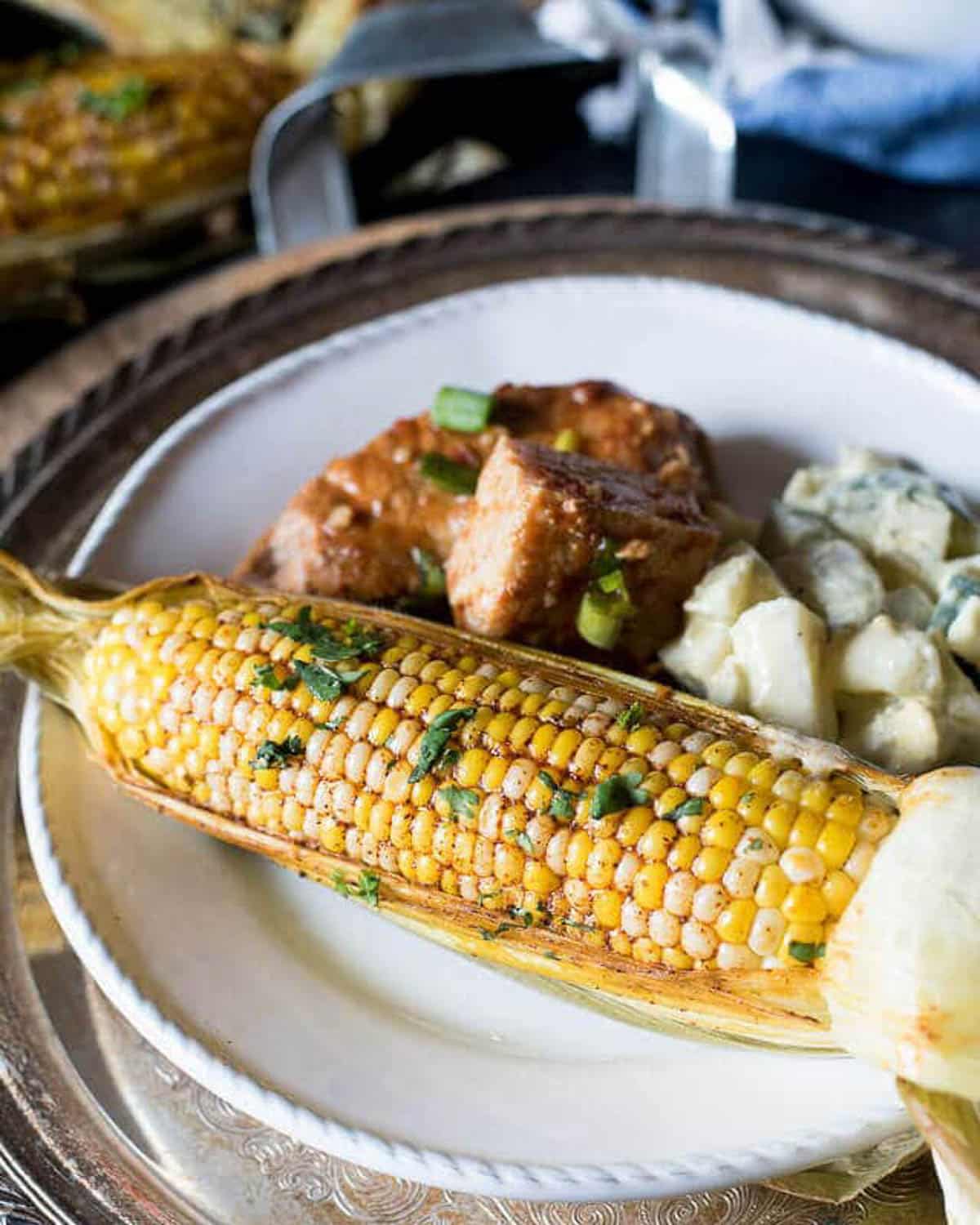 a plate with corn, pork and potatoes