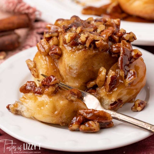 pecan sticky bun on a plate with a bite on a fork