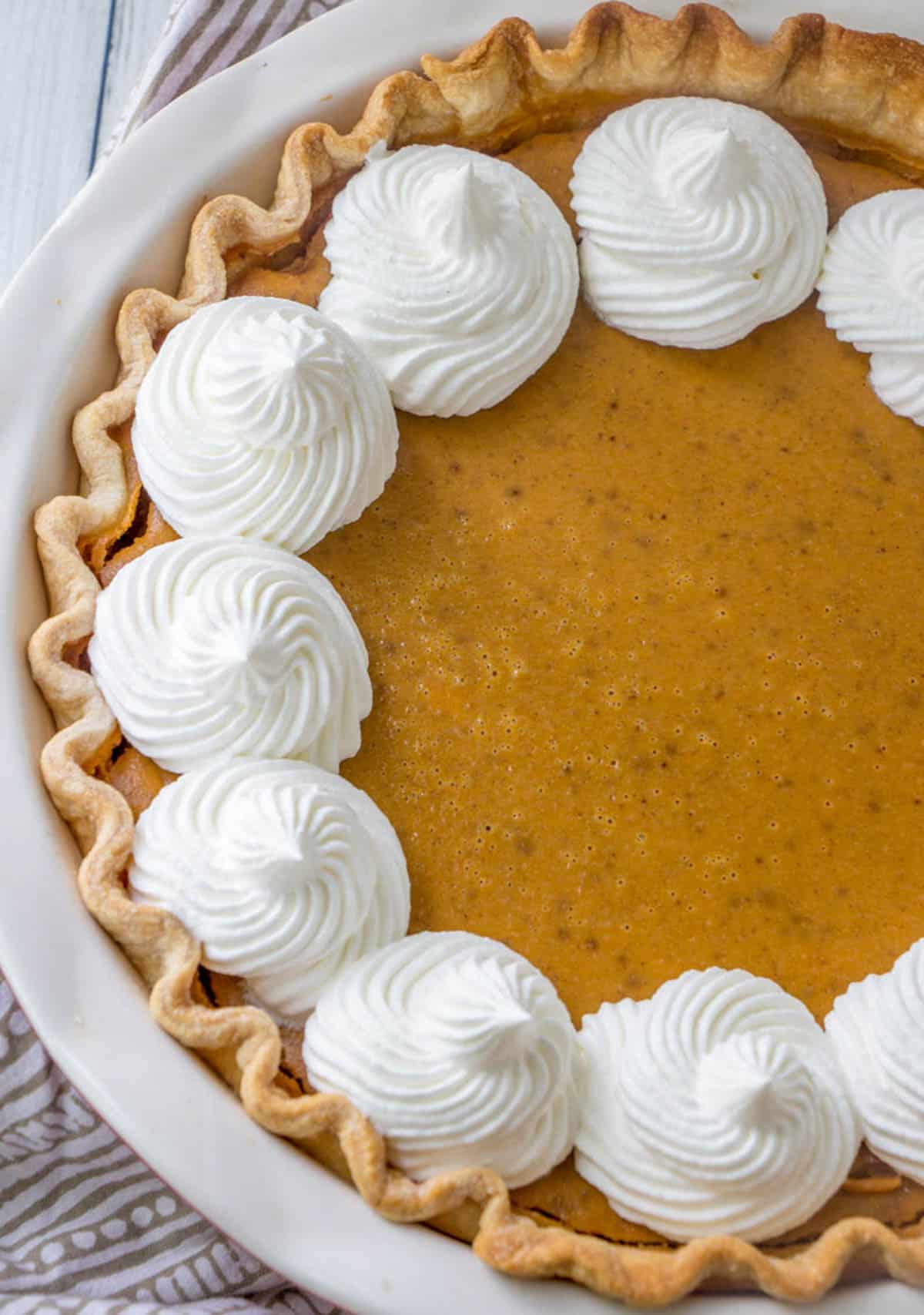 overhead view of 10 inch pumpkin pie with whipped cream on top