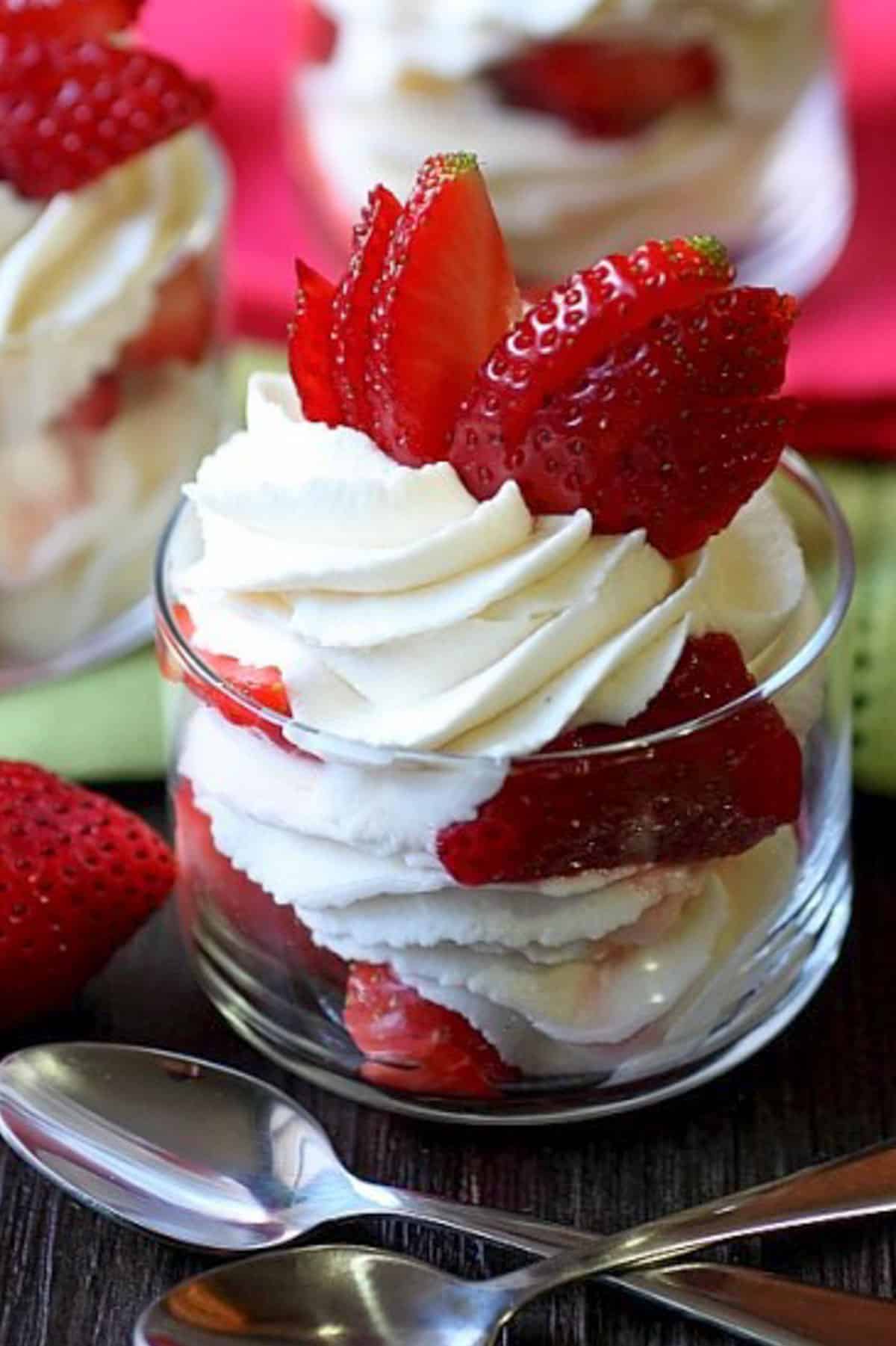 strawberries and whipped cream in a glass cup