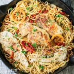 overhead view of chicken piccata with sun dried tomatoes in a skillet