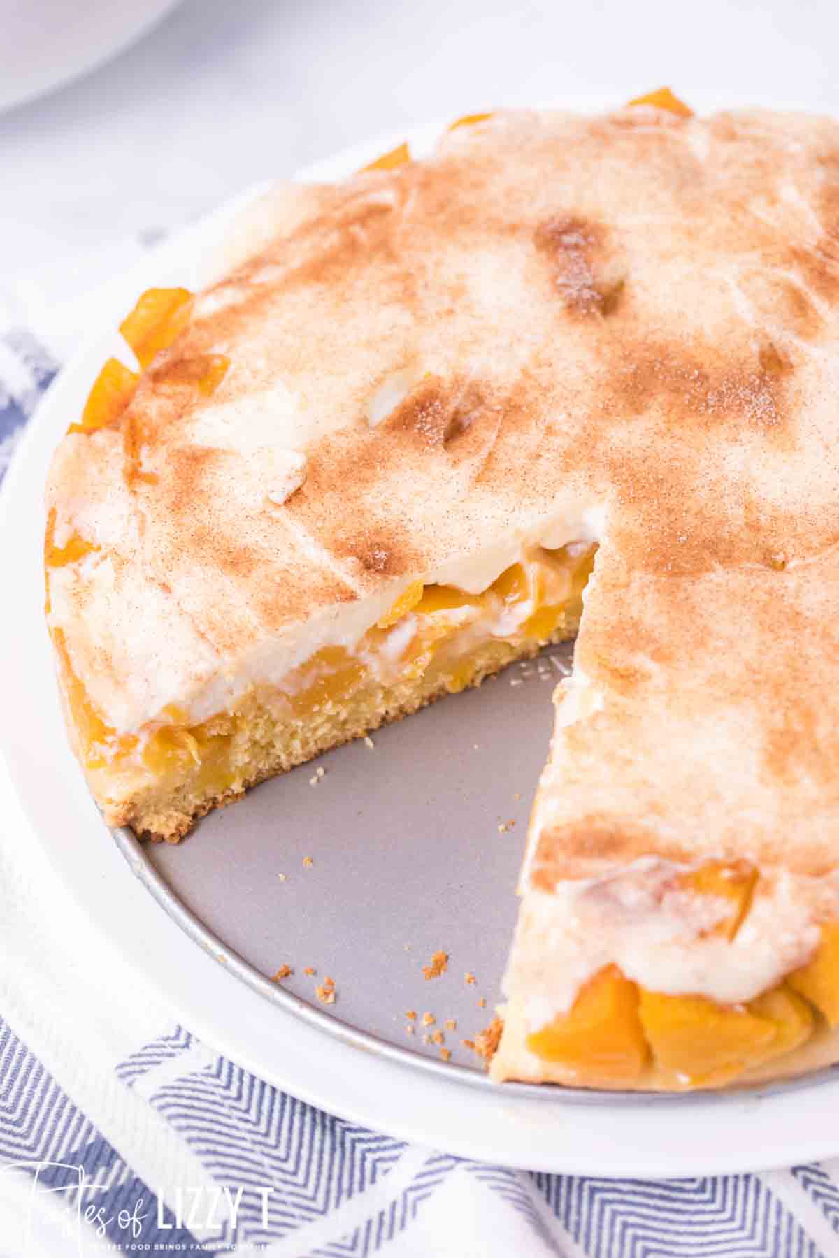 peaches and cream cake with a slice out of it