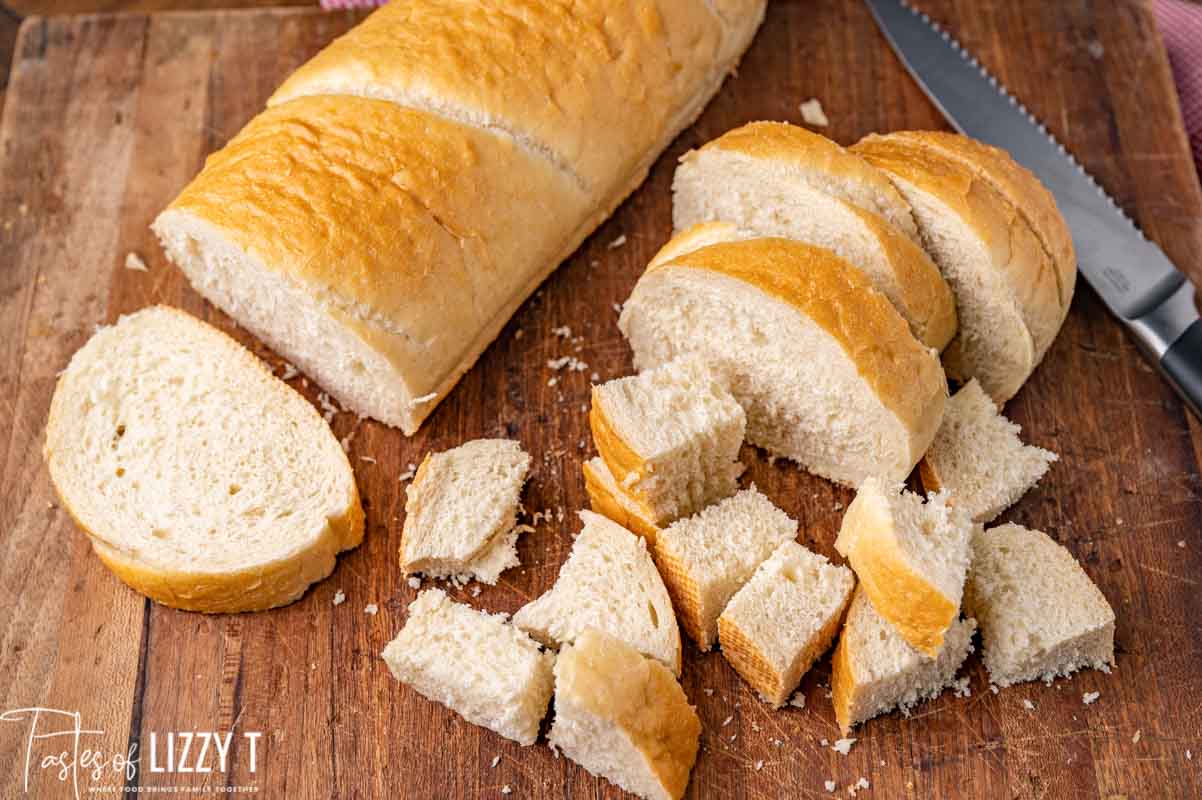 French bread cut in cubes on a cutting board