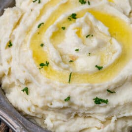 closeup of creamy mashed potatoes in a bowl with butter