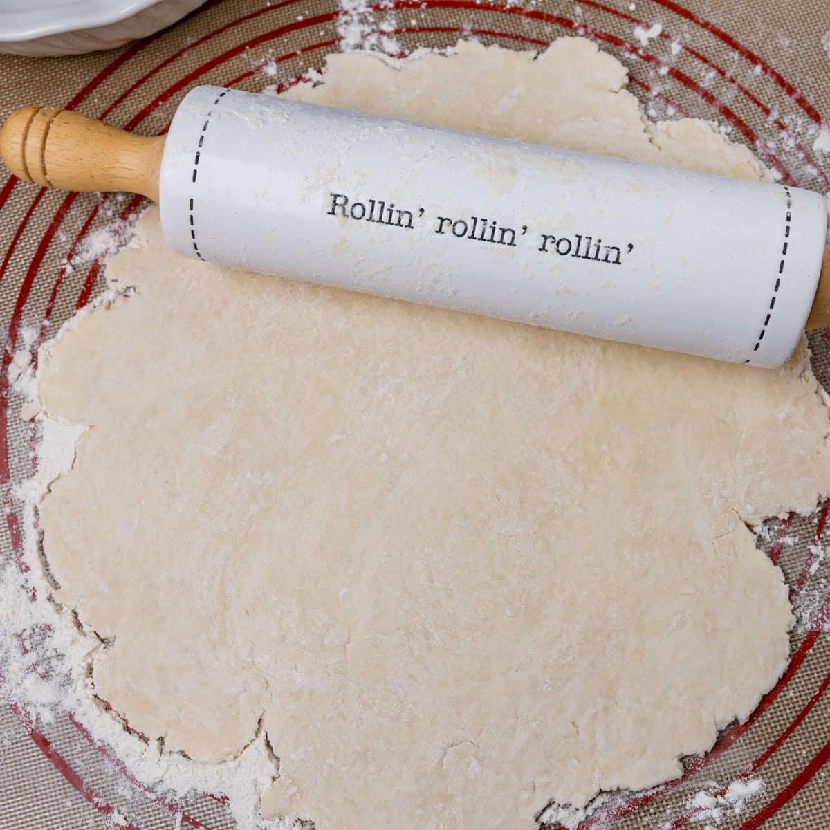 rolling pin sitting on top of rolled out pie dough