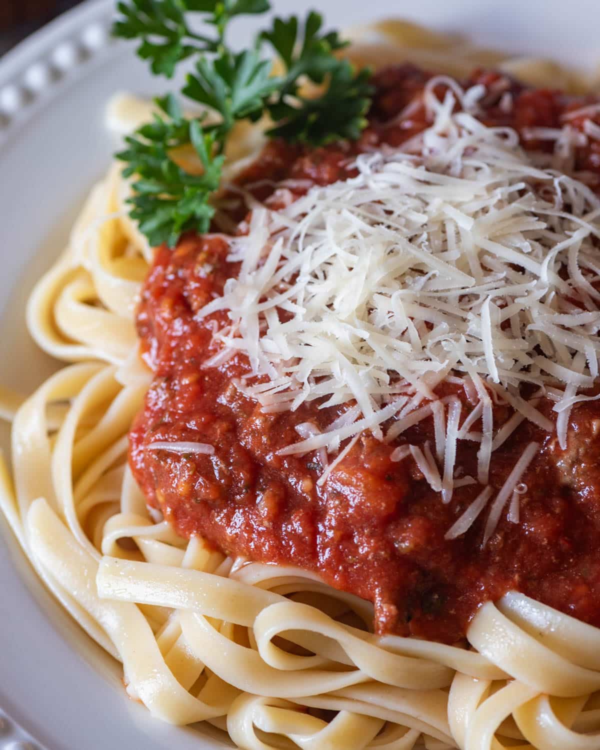 overhead view of a plate of spaghetti with healthy spaghetti sauce and cheese