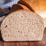 a piece of honey wheat bread sitting on a cutting board