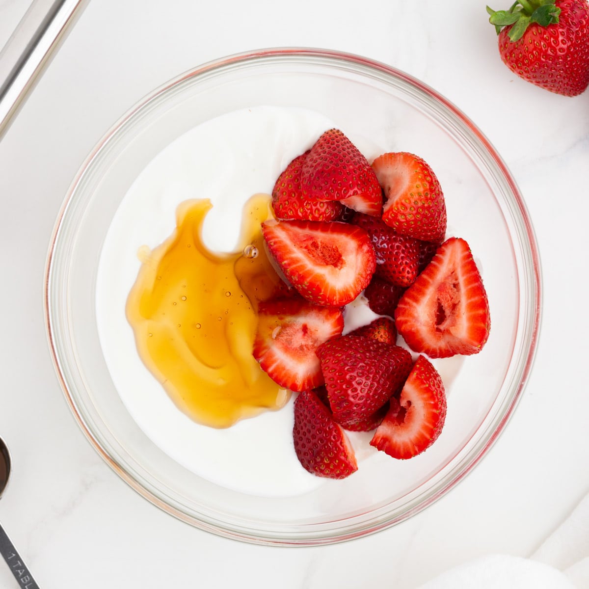 yogurt, honey and strawberries in a bowl