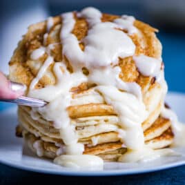 a stack of cinnamon roll pancakes with glaze