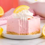 a pink lemonade pie square sitting on a plate with a fork bite out