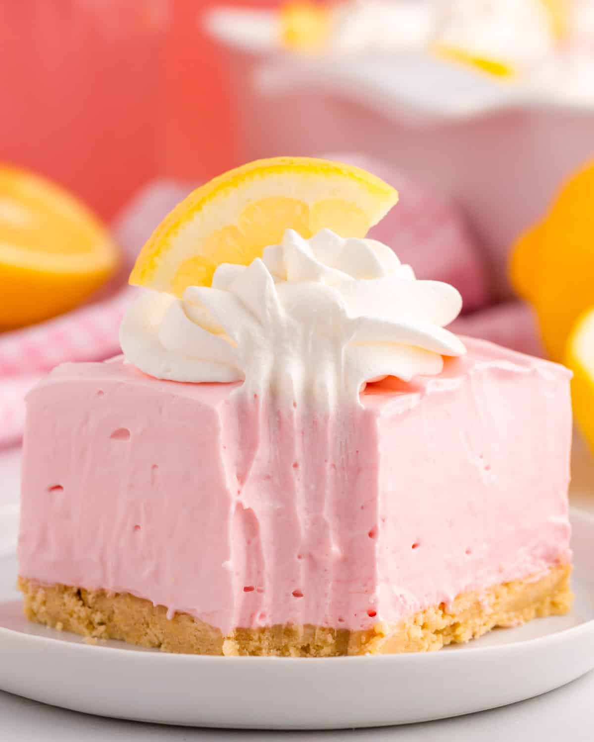 closeup of a pink lemonade no bake bar on a plate with a bite out