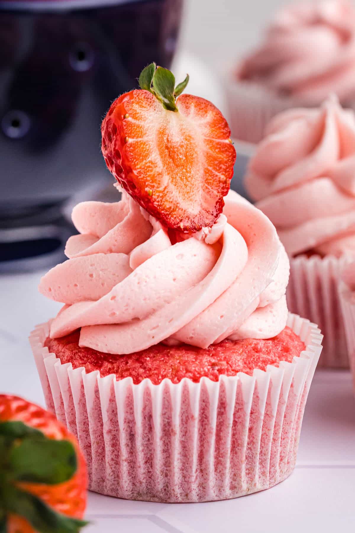 strawberry cupcakes with frosting and a strawberry on top