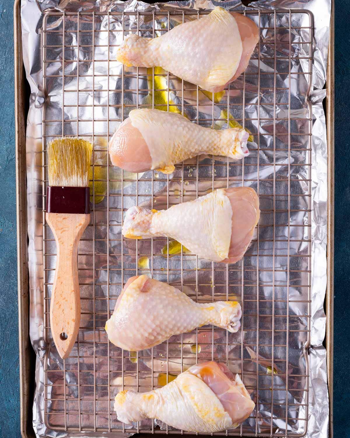 unbaked chicken legs on a wire baking rack