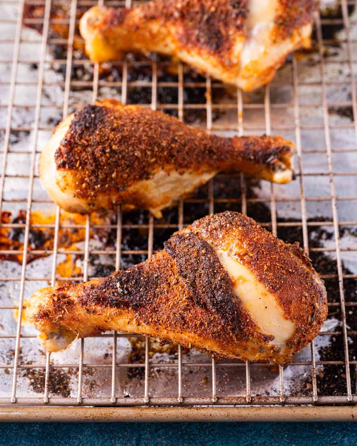 closeup of baked chicken legs on a wire rack