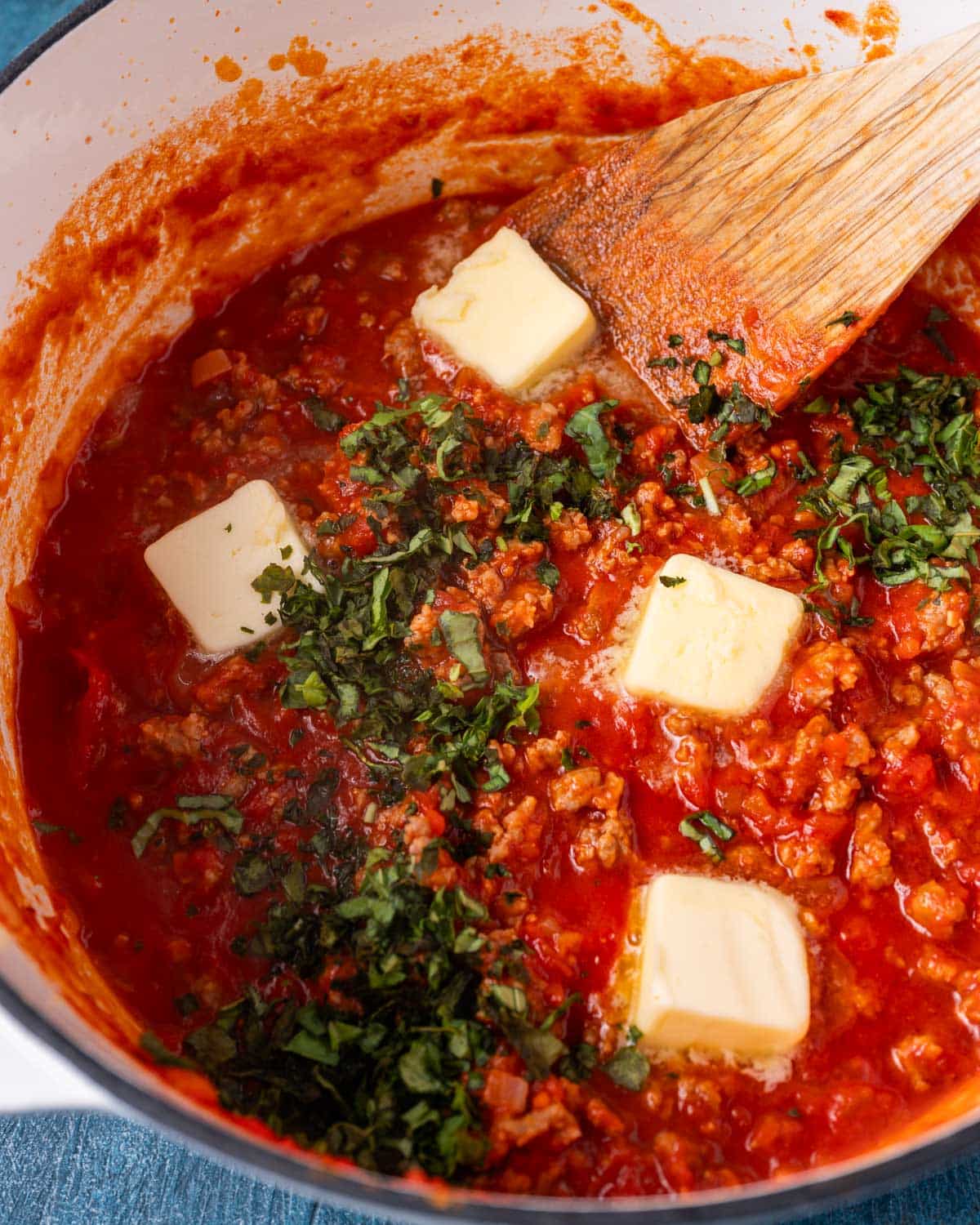 sausage spaghetti sauce with butter and basil on top