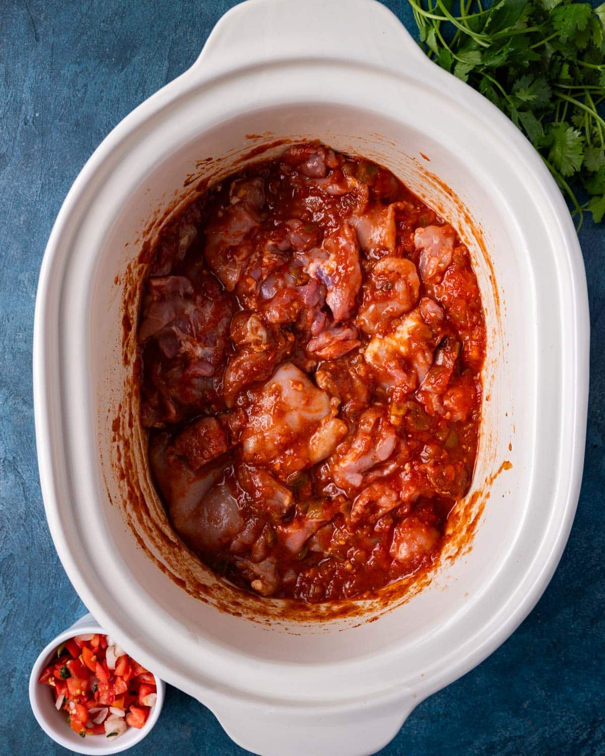 overhead view of uncooked chicken in a crockpot