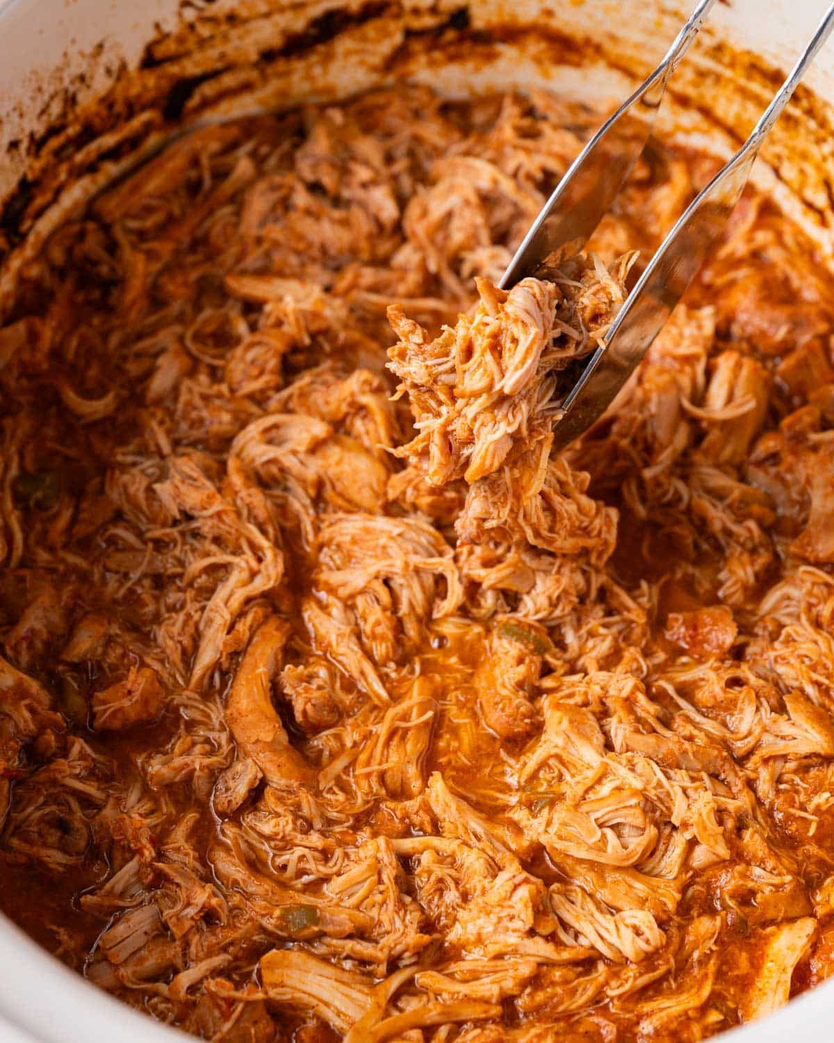 a spatula pulling out shredded chicken for tacos