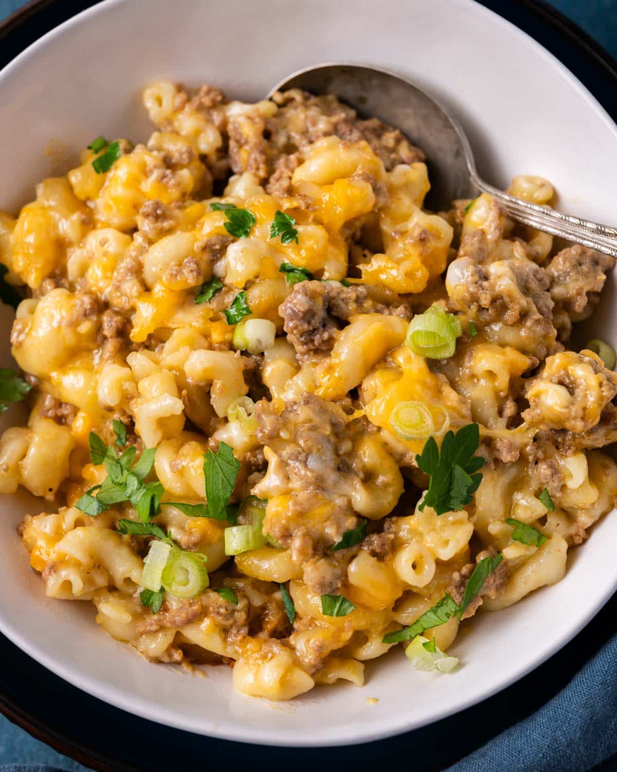a bowl of cheesy hamburger pasta in a slow cooker