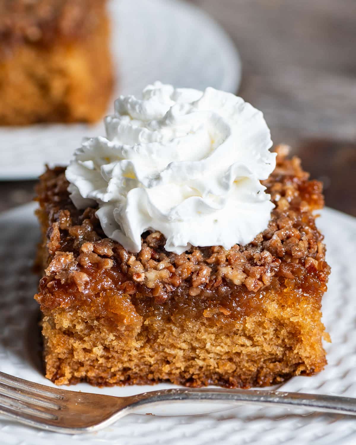 amish cake with whipped cream on top on a plate with a fork