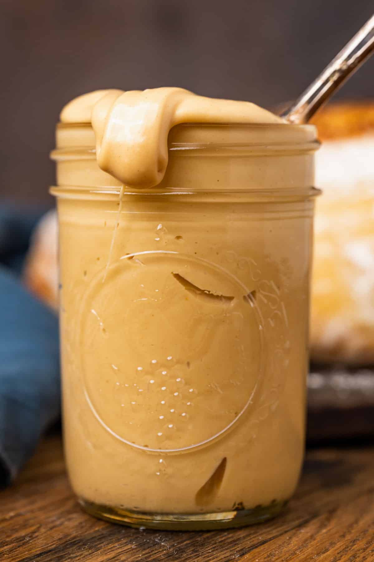 amish peanut butter spread in a glass jar with a spoon