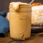 amish peanut butter spread in a glass jar with a spoon