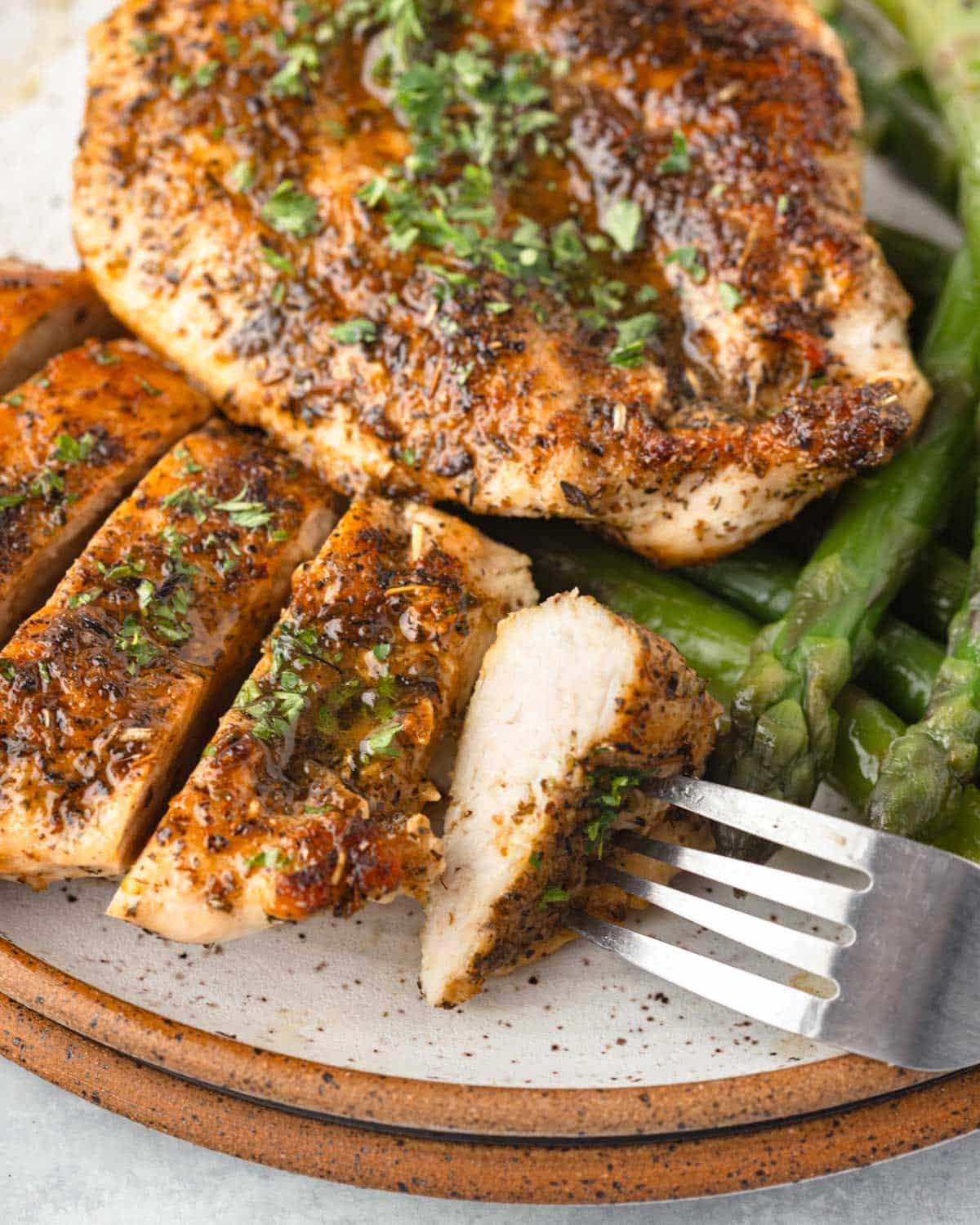 Overhead view of a piece of sliced chicken on a plate with asparagus