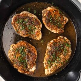 Overhead view of 4 chicken breasts in a cast iron skillet