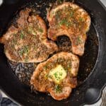 Overhead view of pork chops in a cast iron skillet