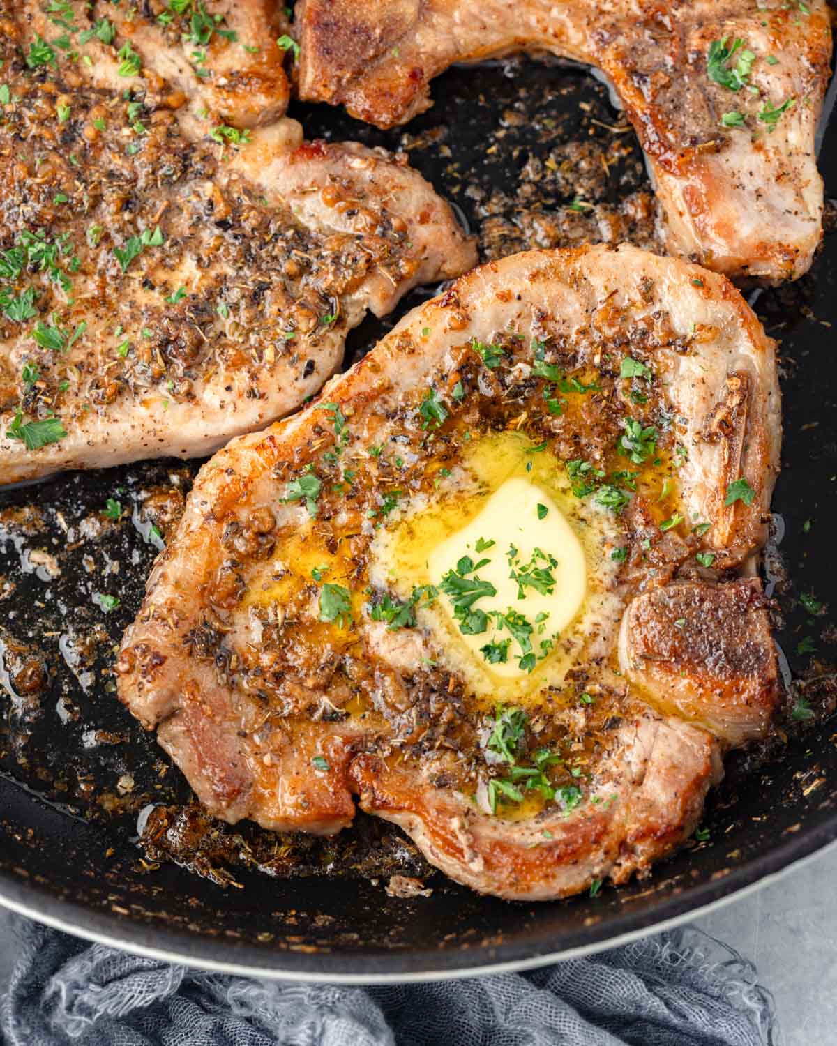 Overhead view of pork chops in a skillet