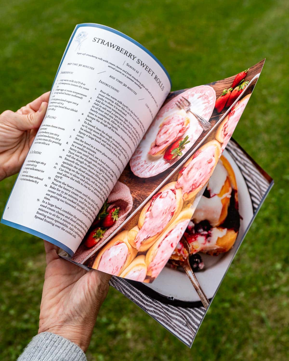 Hands holding a cinnamon roll cookbook