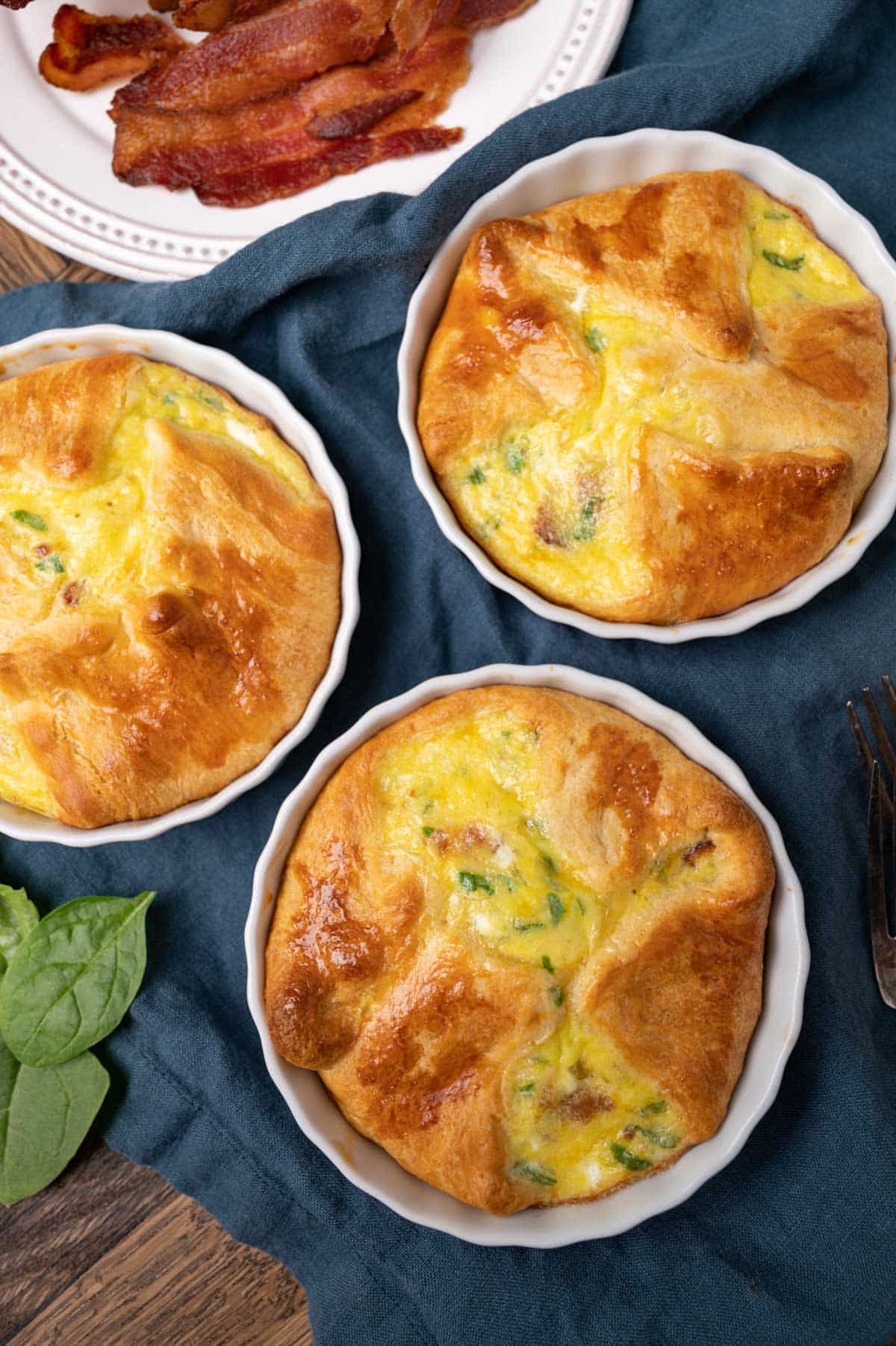 over head view of a breakfast table with egg souffles and bacon