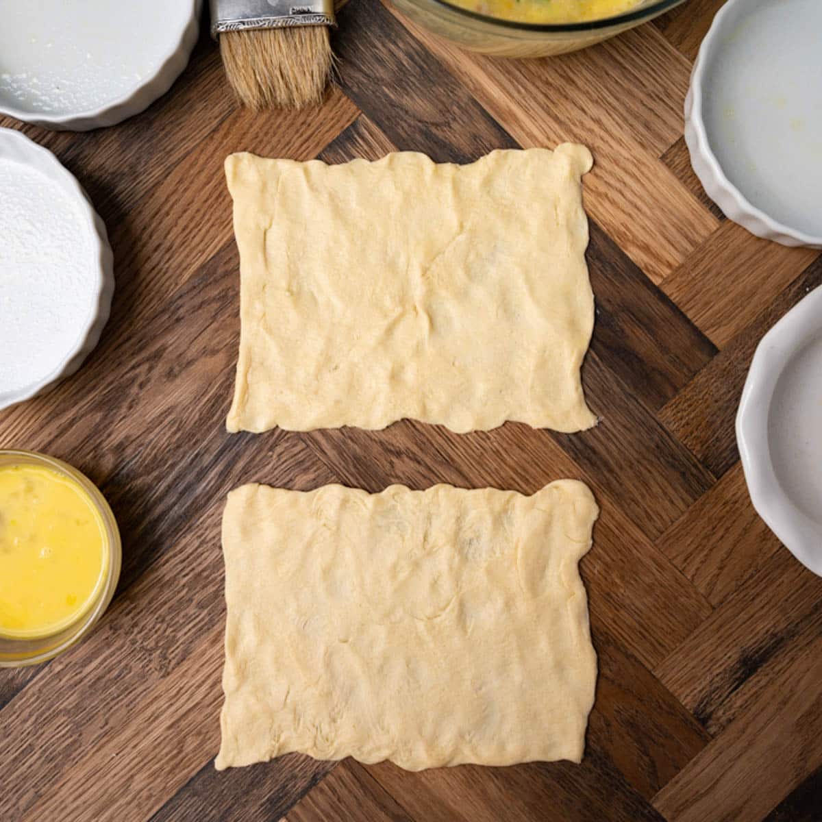 crescent roll dough pressed into rectangles on a table