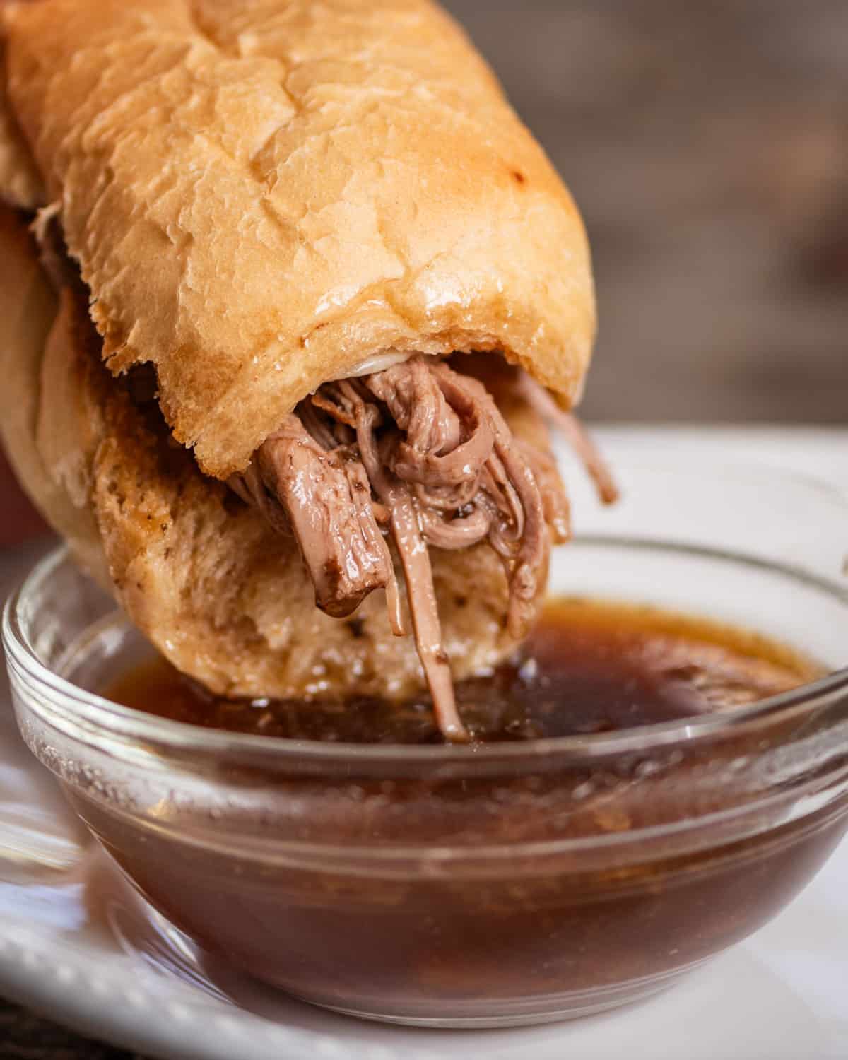 french dip sandwich dipping in broth