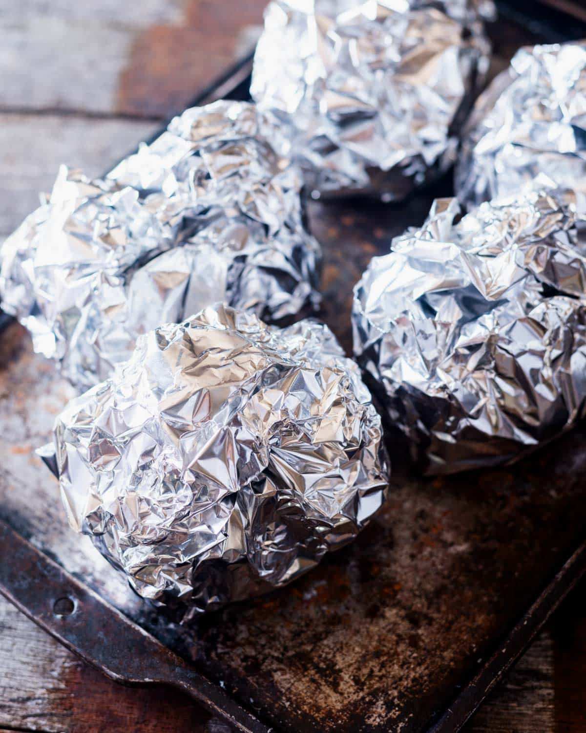 hasselback potatoes wrapped in foil, ready for the grill