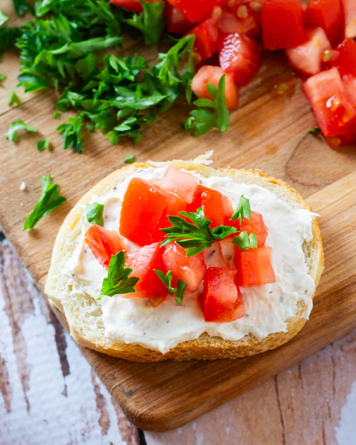 a mini italian tomato sandwich on a cutting board