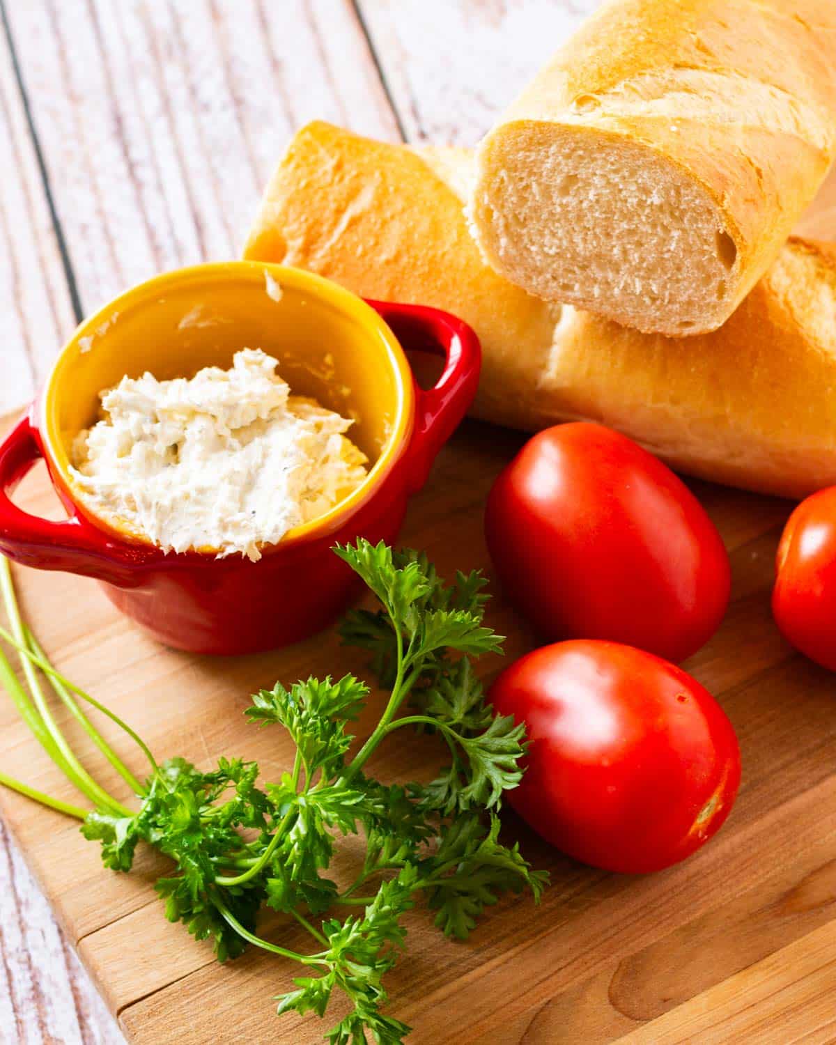 ingredients for italian tomato sandwiches on a cutting board