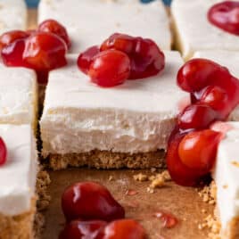 closeup of no bake cheesecake bars with cherries on top