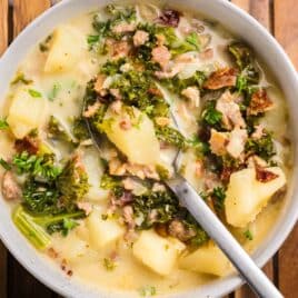potato sausage kale soup in a bowl with a spoon