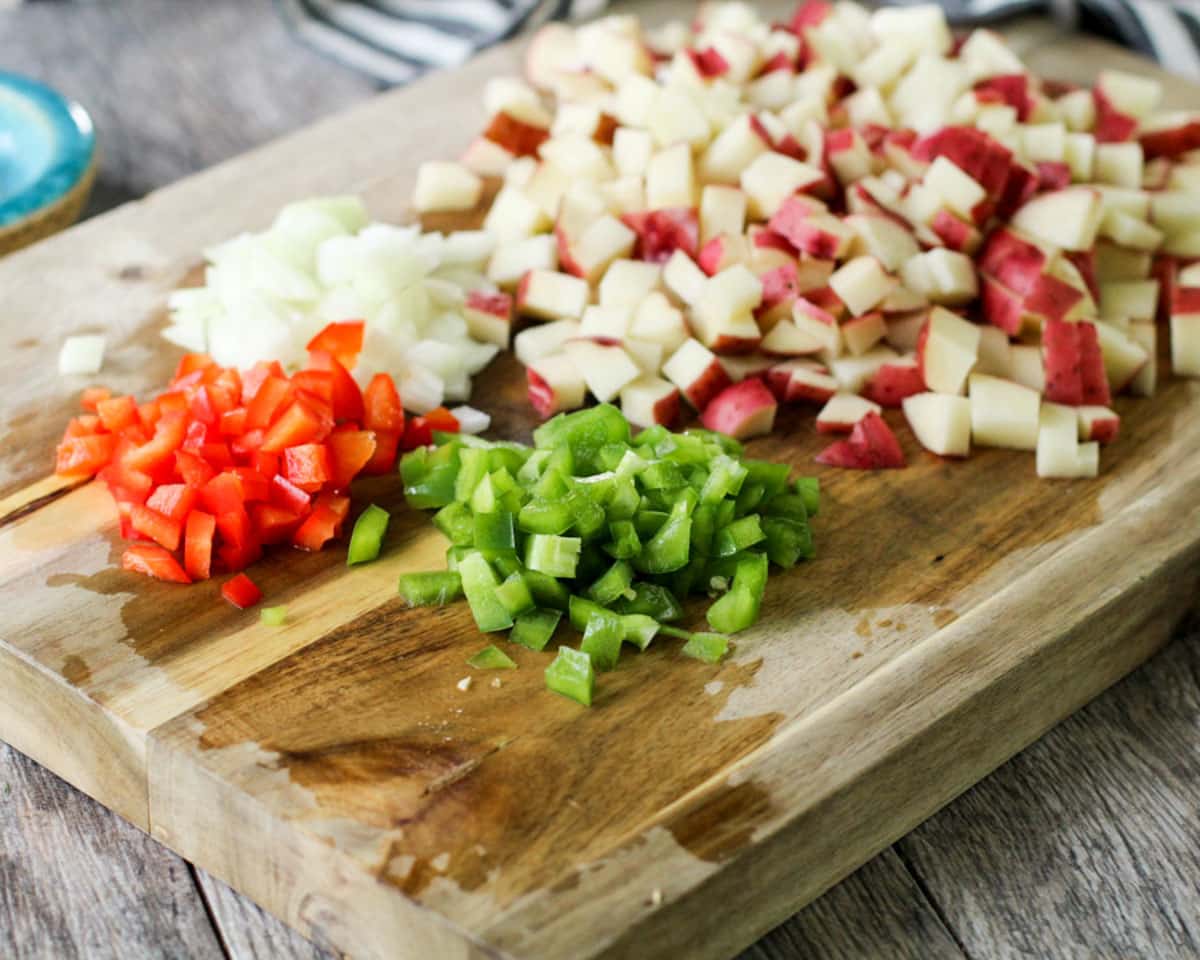 potatoes and peppers diced up on a cutting board