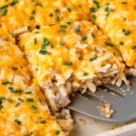 a spatula under a cut piece of hash brown casserole