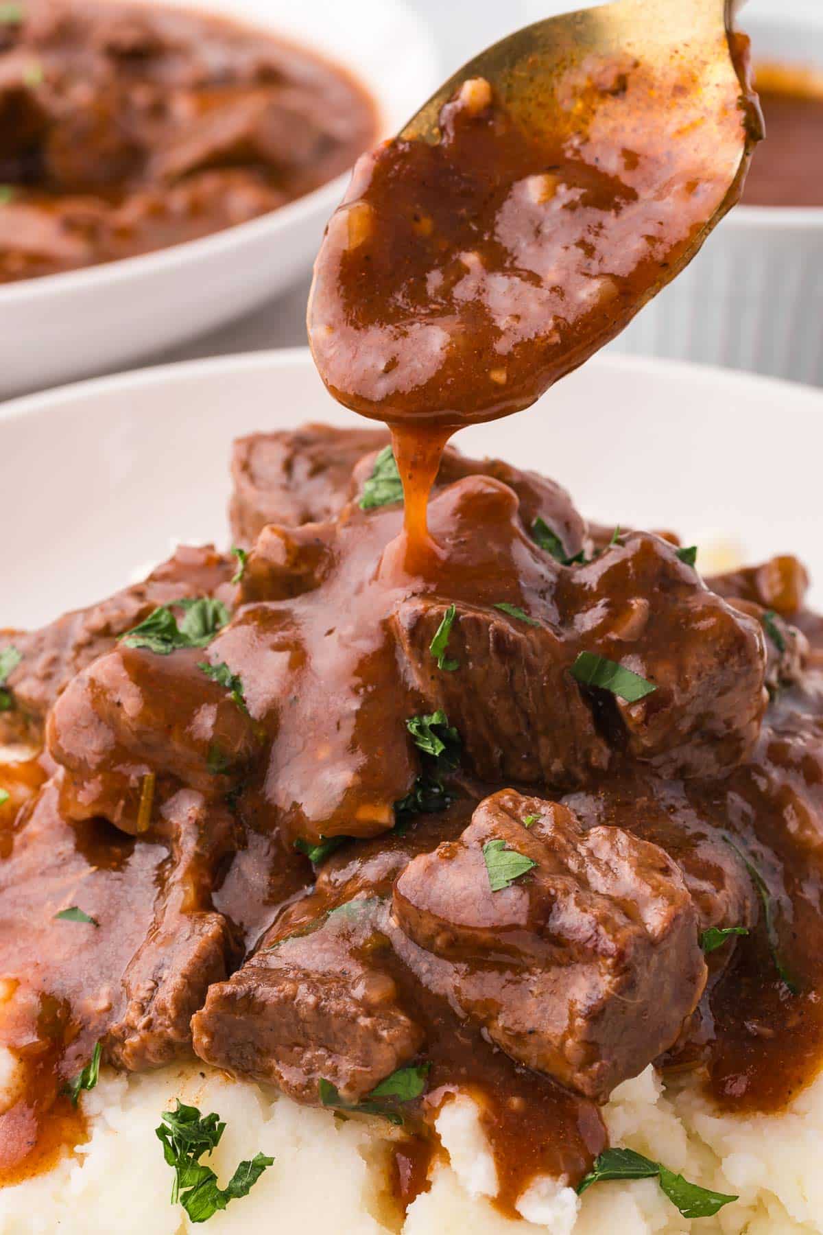 spooning gravy over beef tips