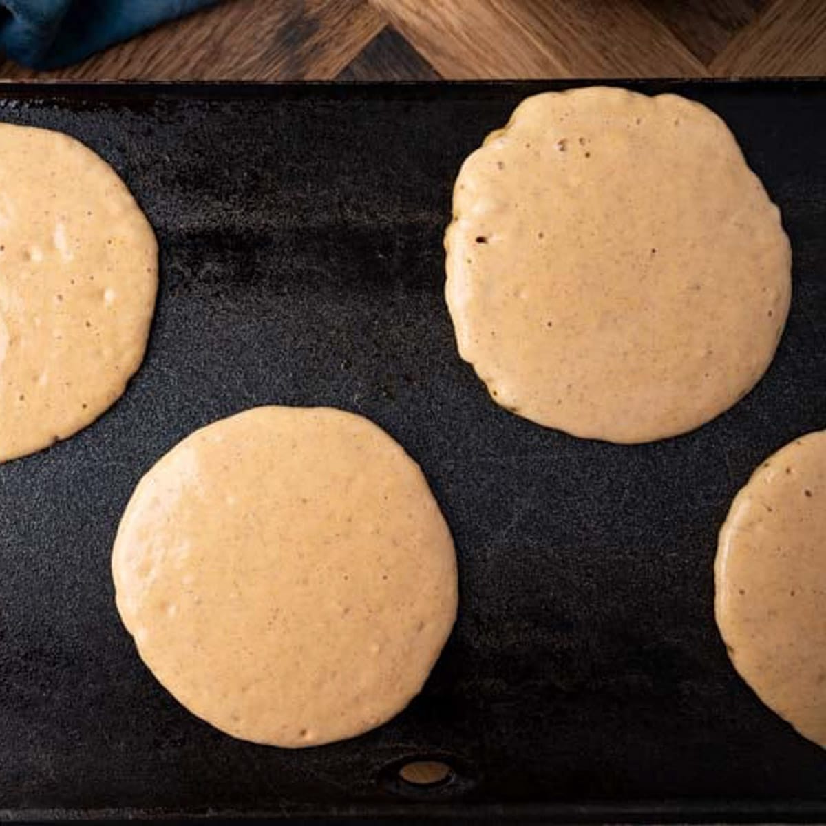 pumpkin pancakes cooking on a griddle