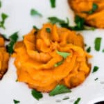 a twice baked sweet potato swirl on a plate with fresh parsley