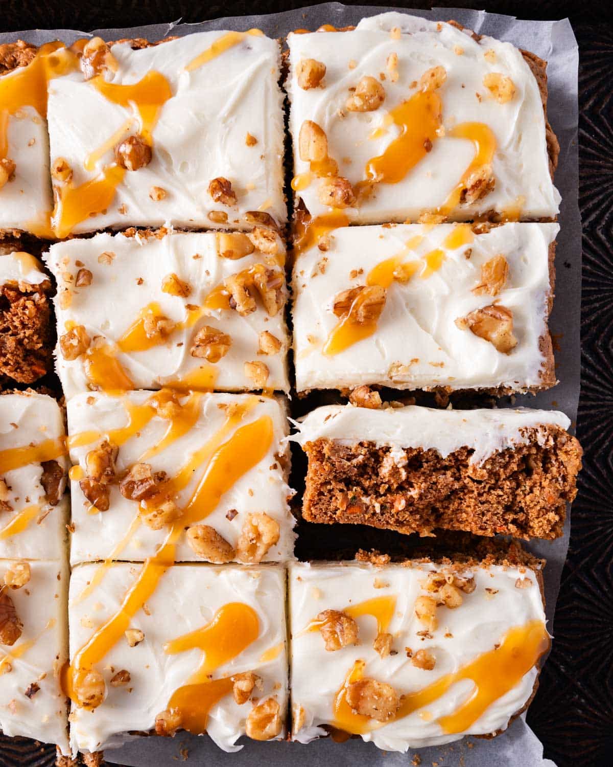 closeup of 12 frosted zucchini bars with walnuts and caramel