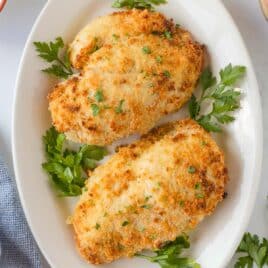 closeup of two pieces of ranch chicken on a plate with parsley