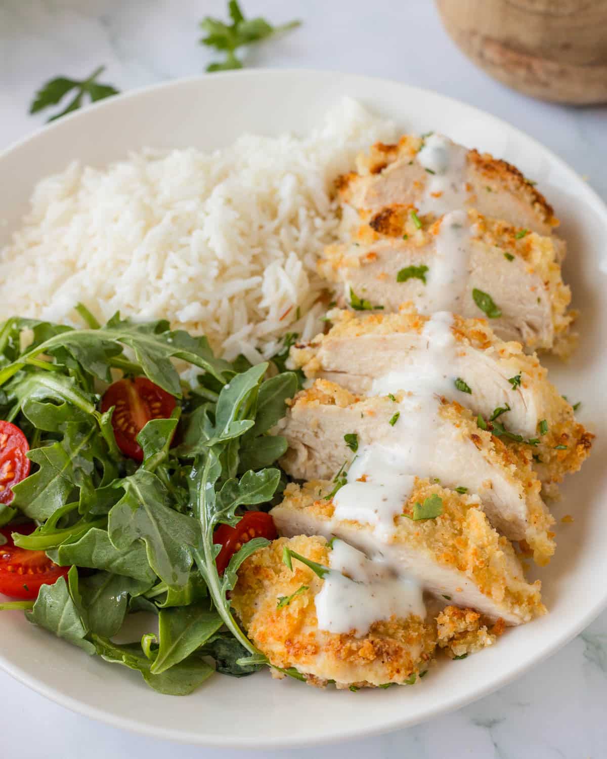 ranch chicken with rice and salad on a plate