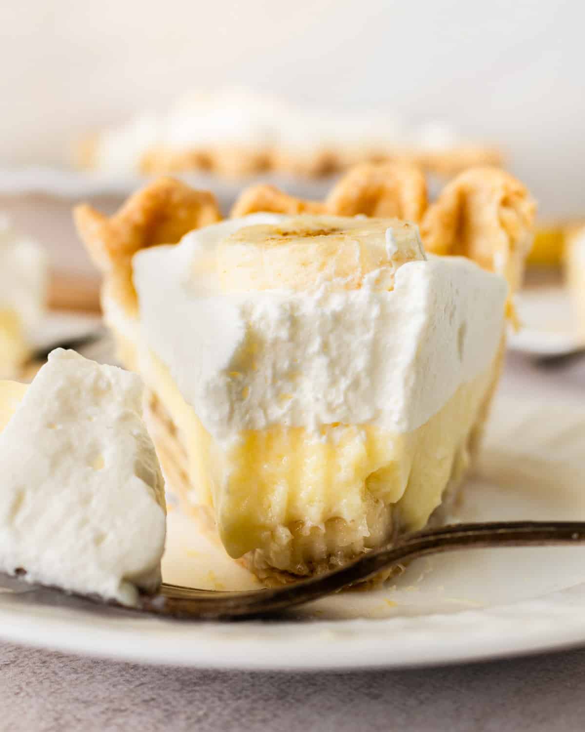 closeup of a slice of banana cream pie, with one bit missing