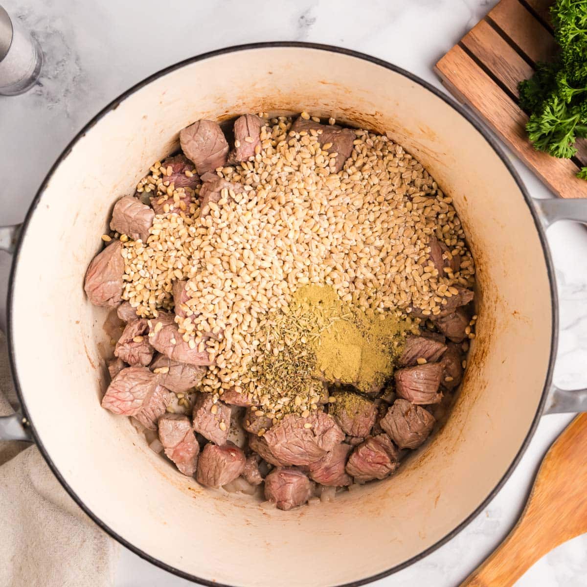 ingredients for beef barley soup in a dutch oven