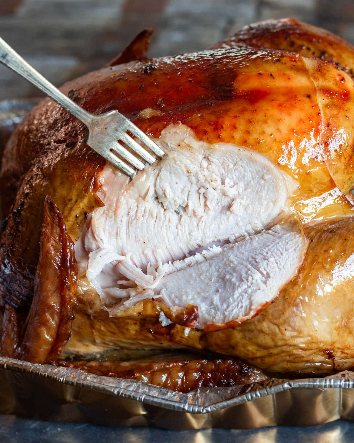 a smoked turkey with a slice out with a fork in it