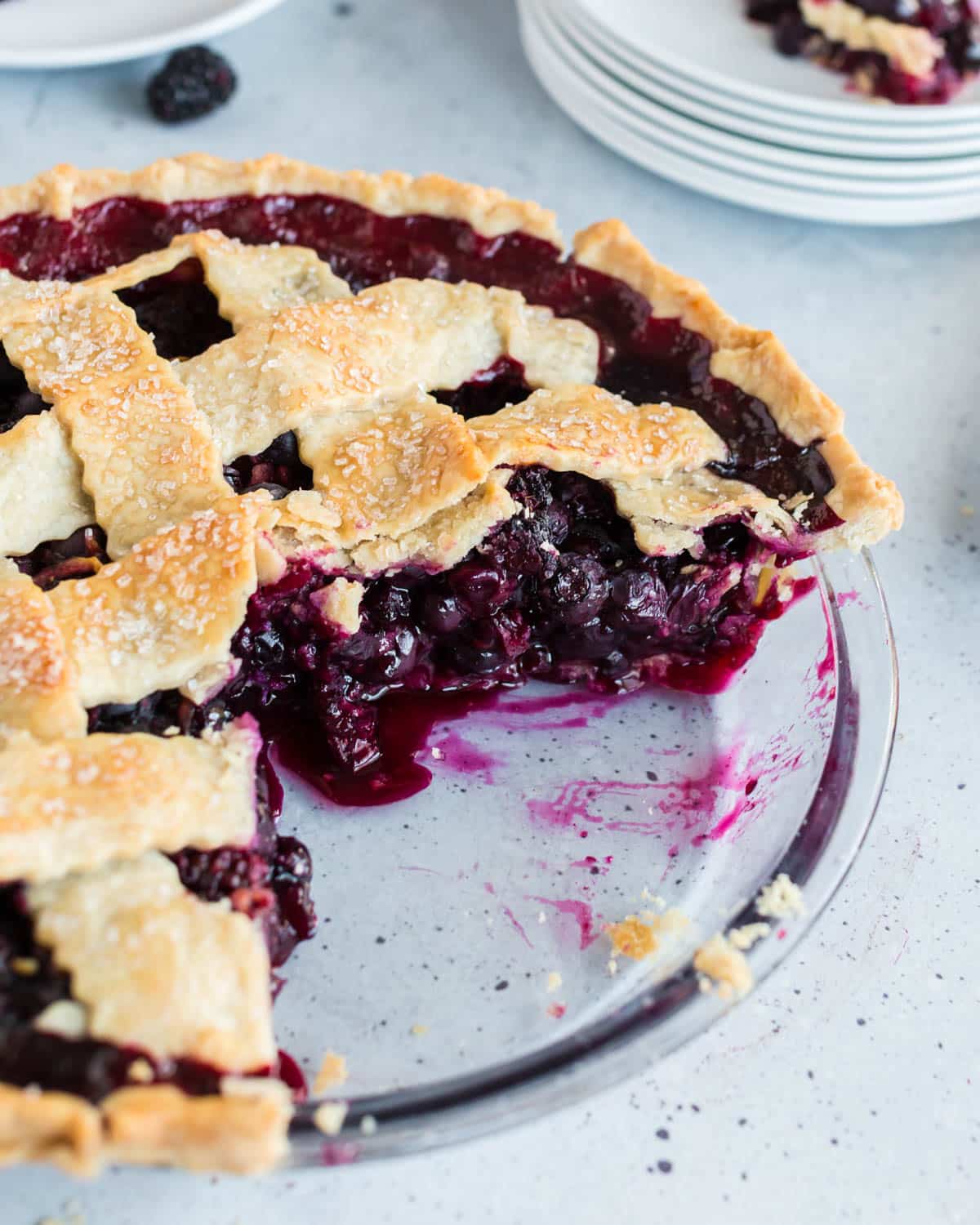 blueberry blackberry pie in a pan with a slice cut out